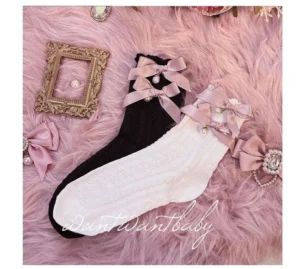 Flat lay top-down view of black and white lolita short socks with satin pink bow, pearl and rhinestone embellishment, cable knit texture detail, pink faux fur backdrop