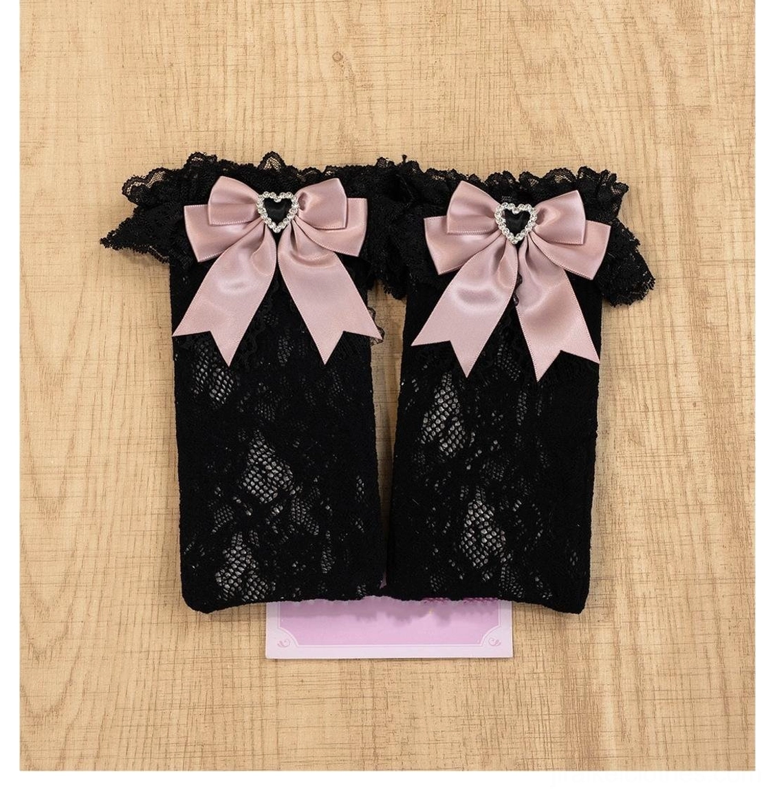 Black-pink jirai kei lace socks with heart-shaped rhinestones and decorative satin bows in contrasting dual-tone aesthetic