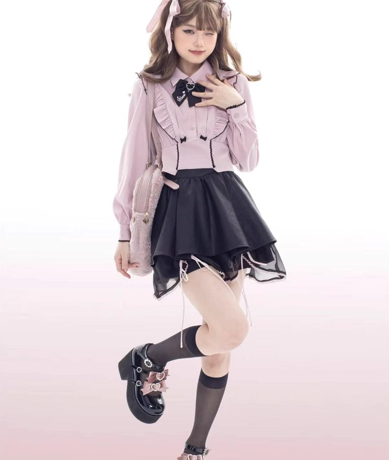 Low-angle full body pose of model in black platform loafers with ankle buckle strap and bow decoration, wearing black socks against white background