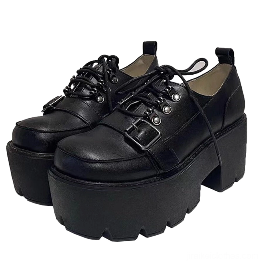 Pair of black platform shoes overhead side view on white table showing metal eyelets heel pull tab and smooth leather texture