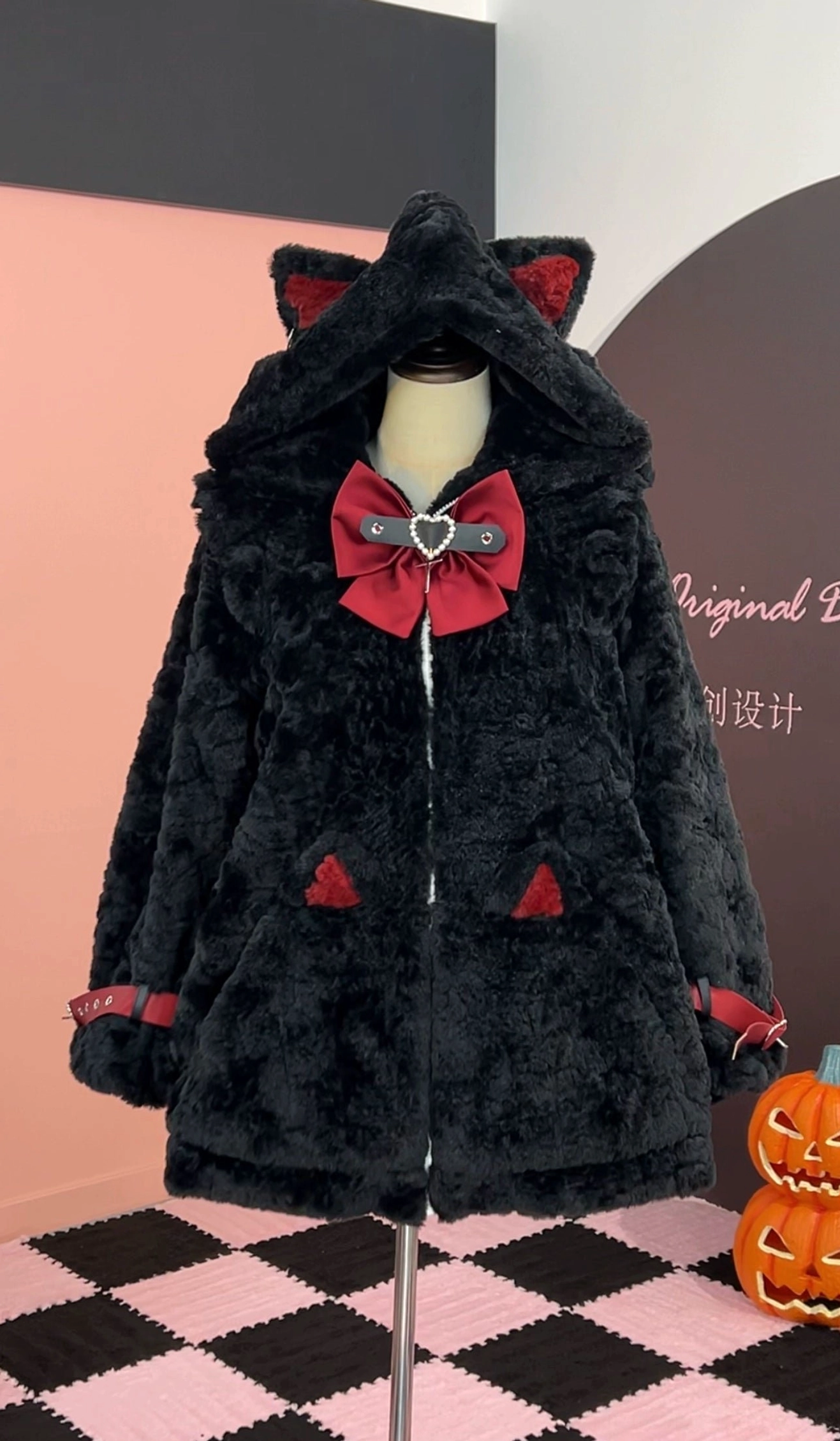 Black and red Jirai Kei fleece coat with cat ear hood, red bow decoration, buckle strap details, and red hood ear accents, front display