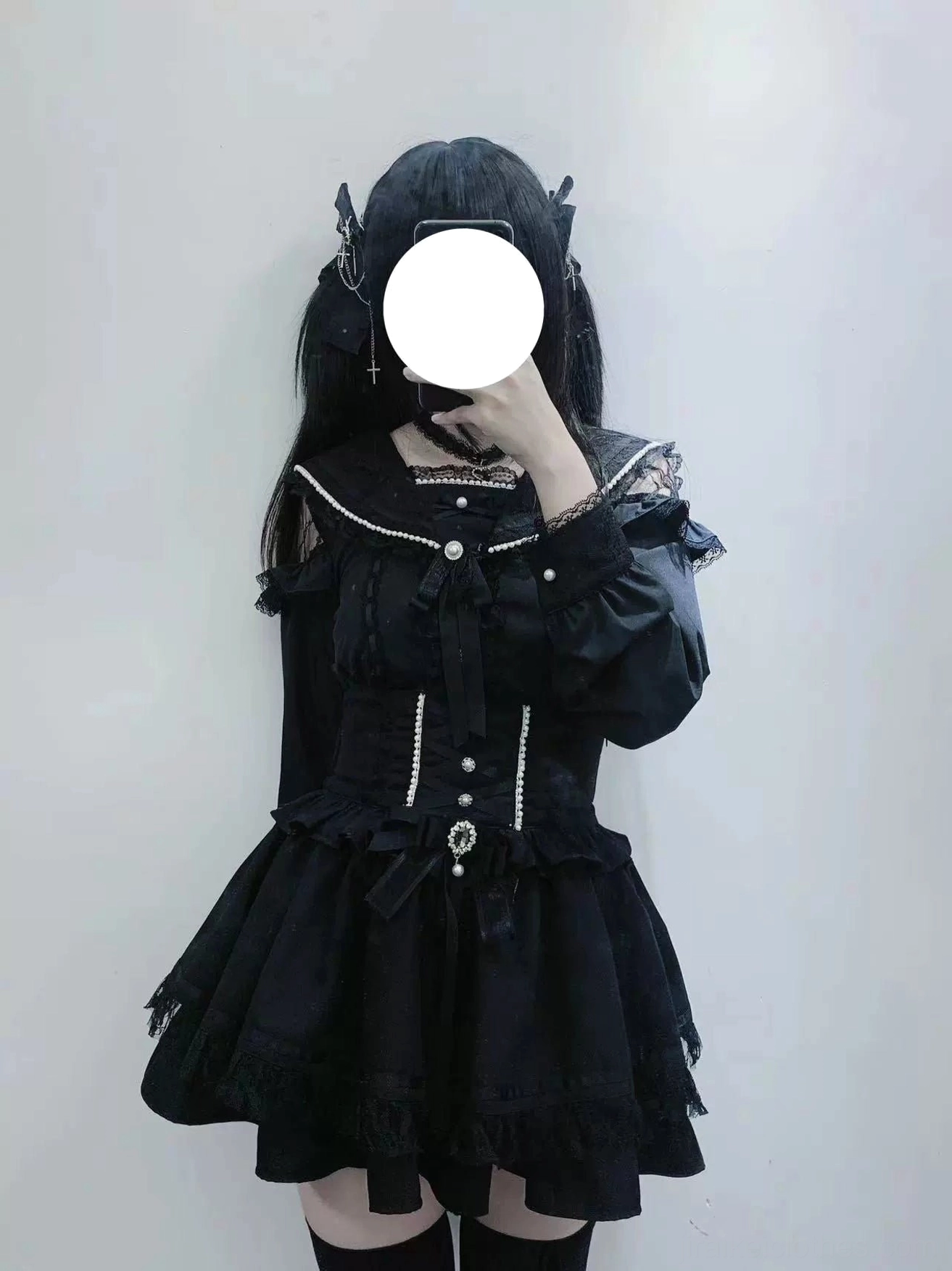Chest-up studio close-up of faceless female model in black Jirai Kei sailor collar top with gothic styling, tiered ruffled design details, and pearl button embellishments throughout