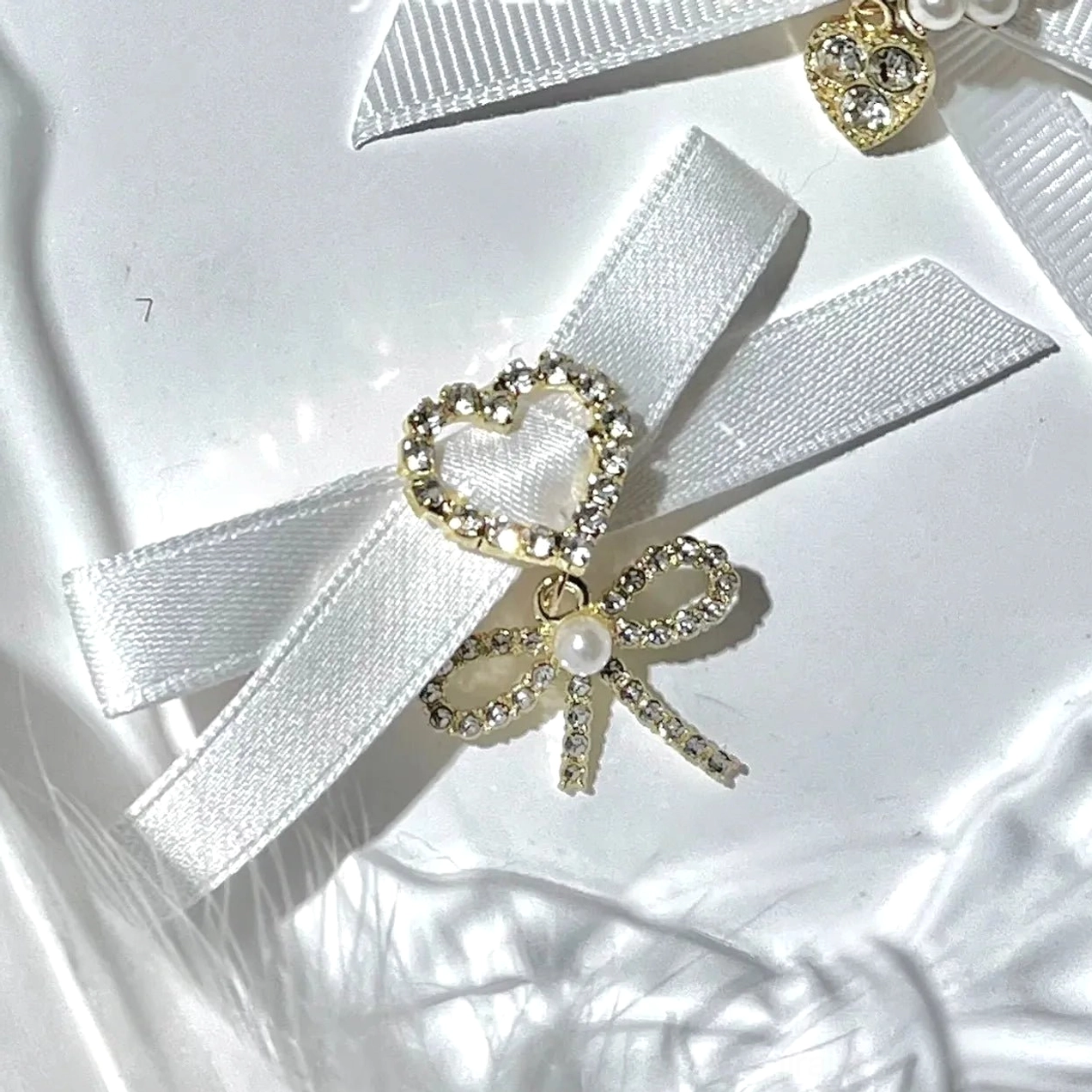 Black swallowtail bow hair clips Jirai Kei fashion with large rhinestone center and dangling heart decoration detail