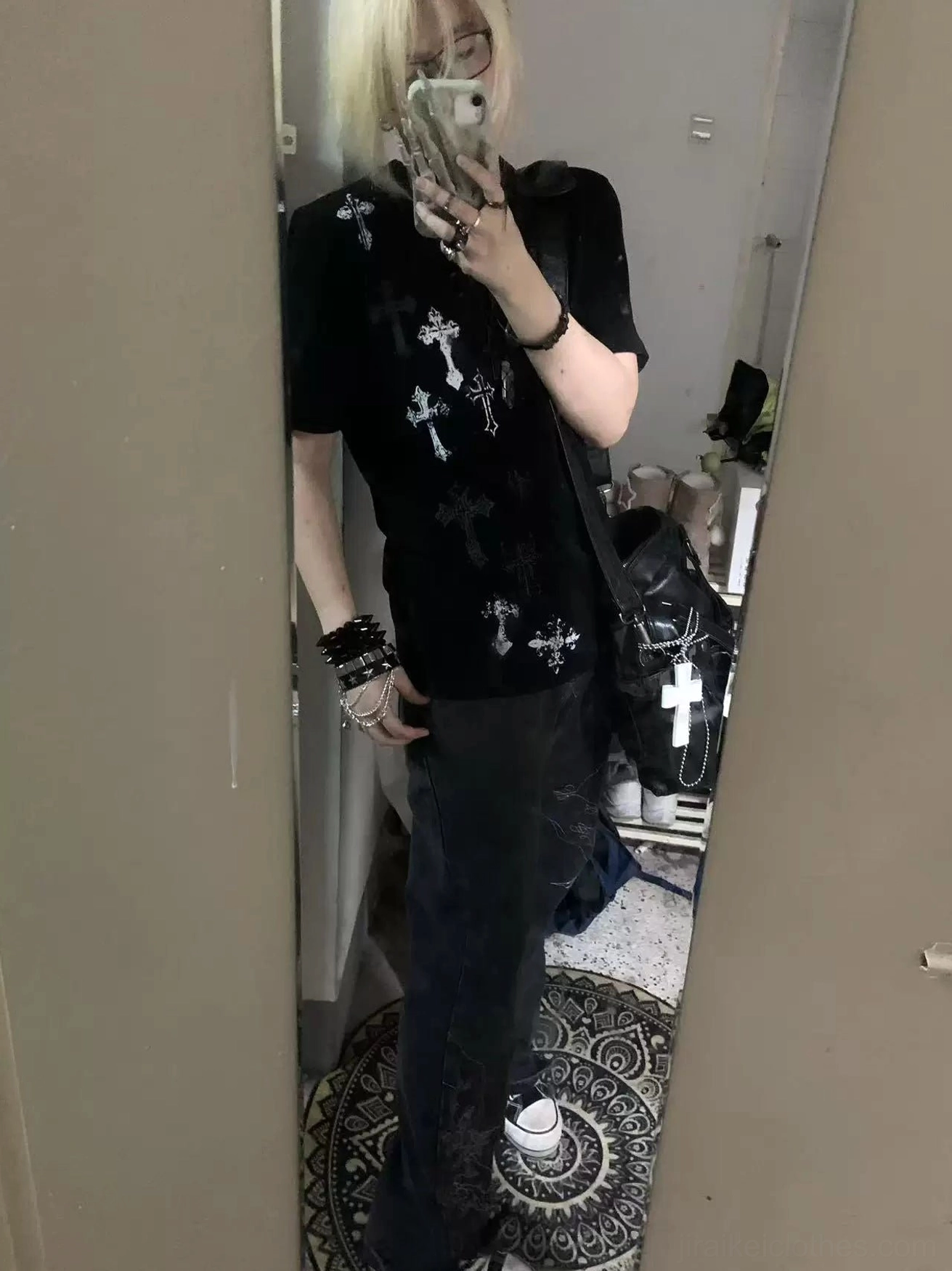 Mirror selfie of person wearing black t-shirt with all-over silver cross prints throughout garment, indoor home environment, jirai kei casual wear