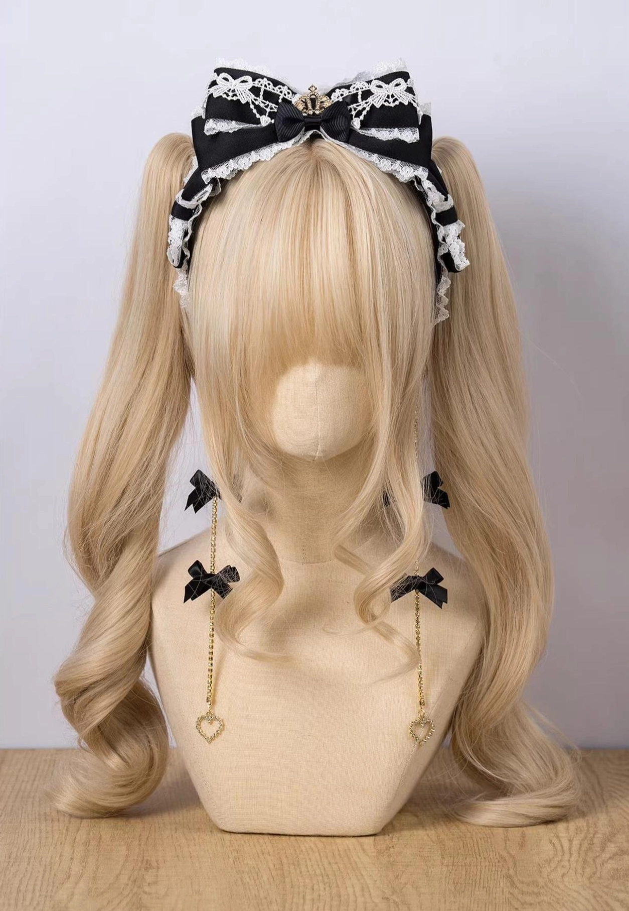 Black white contrast bow KC with dangling heart chains and lace trim on blonde mannequin front view