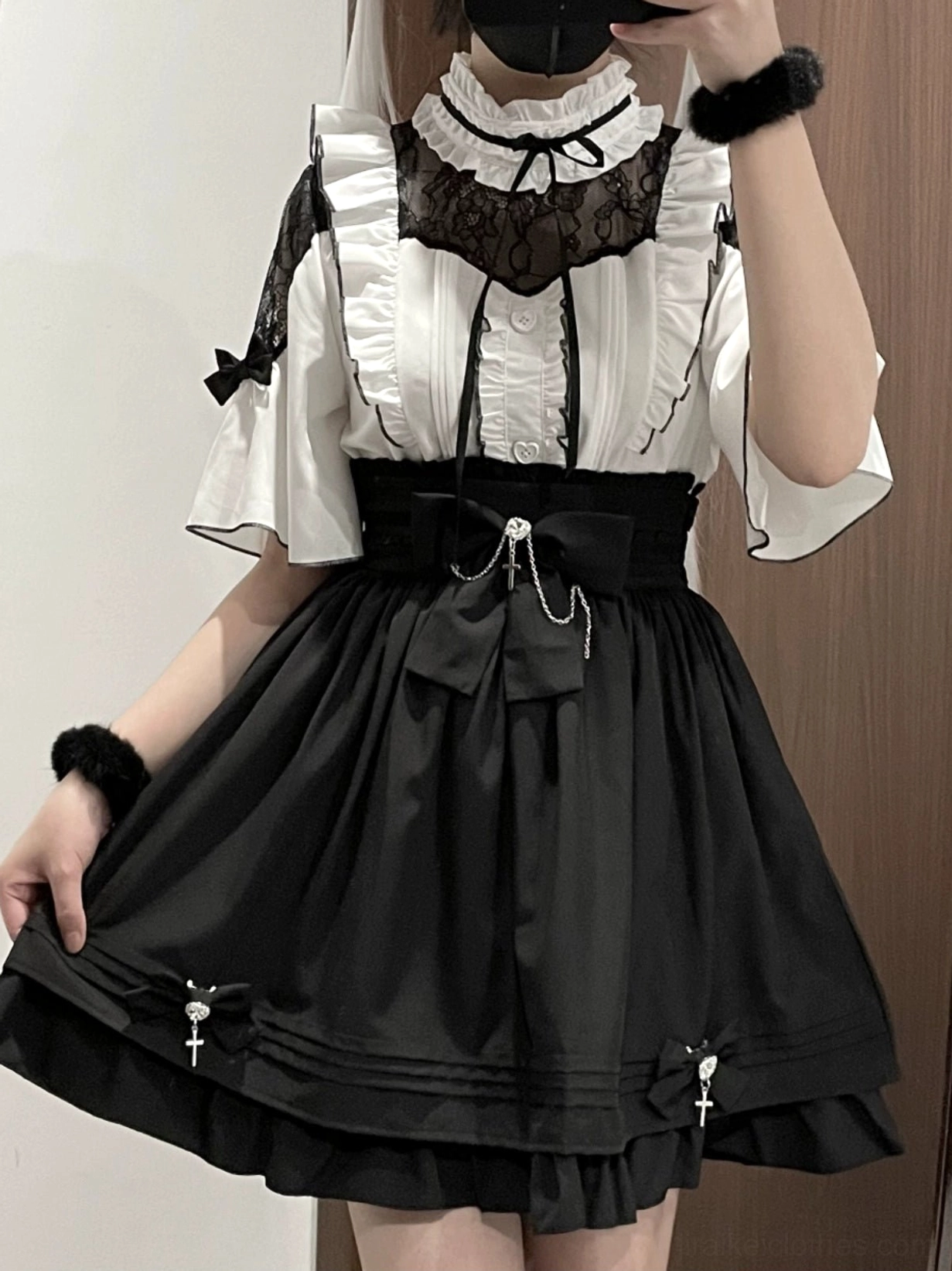 Half-body mirror selfie of black and white jirai kei outfit set with lace collar blouse, high-waist black skirt, bow details and cross pendant accents worn by female model