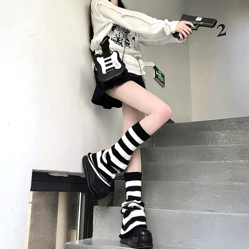 Black and white striped Y2K Jirai Kei leg warmers with slouchy cuffs side view on staircase worn by casual y2k female model