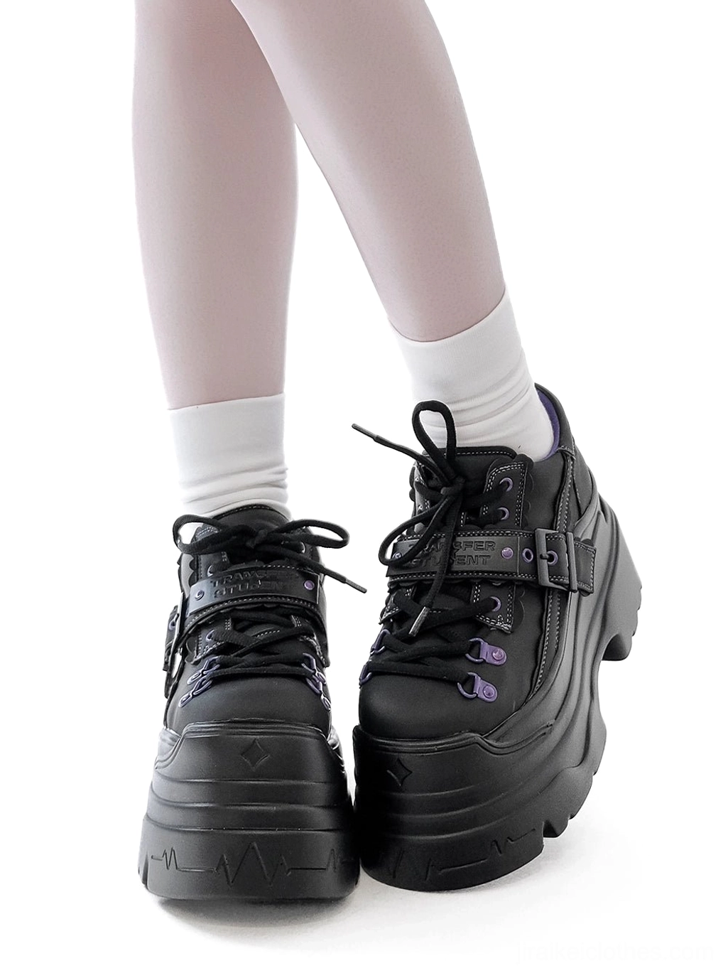Black Y2K jirai kei chunky platform shoes front close-up on female model with white socks, thick sole and purple eyelet lace-up closure