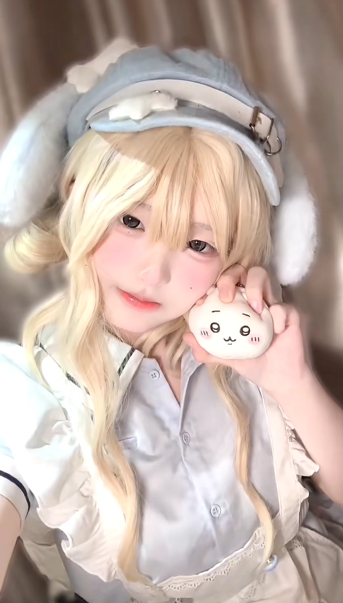 Close-up selfie of blue puppy ear beret worn with maid outfit and chiikawa plush toy, showcasing adorable kawaii styling details