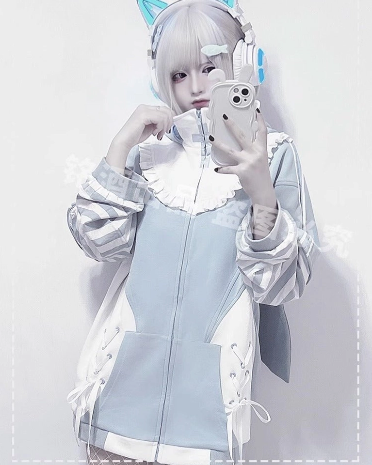 Close-up front mirror selfie of blue zip-up Tenshi Kaiwai hoodie jacket featuring ruffled collar, lace-up side details, striped sleeves, and front pocket on model