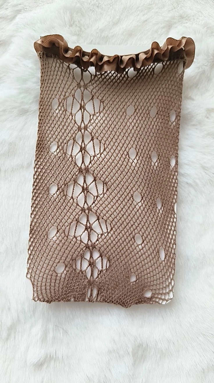 Brown diamond hollow mesh fishnet Jirai Kei stockings with ruffled top edge, flat lay on white fur rug texture