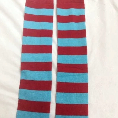 Burgundy and cyan striped over-the-knee socks flat lay, bold color clash horizontal stripes, white fabric background