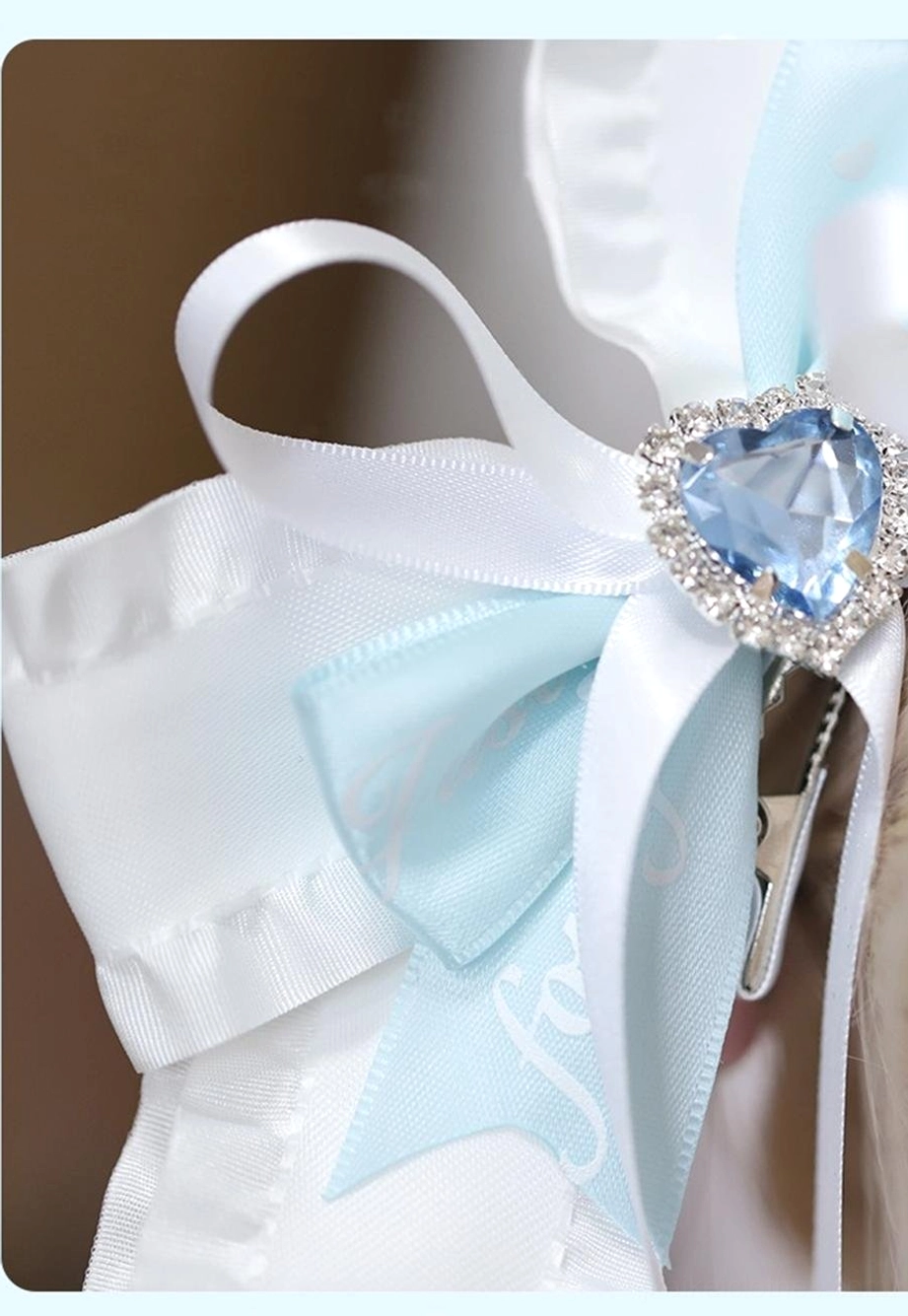Single butterfly bow hair clip top-down close-up showing white ruffled edges and baby blue bow center design