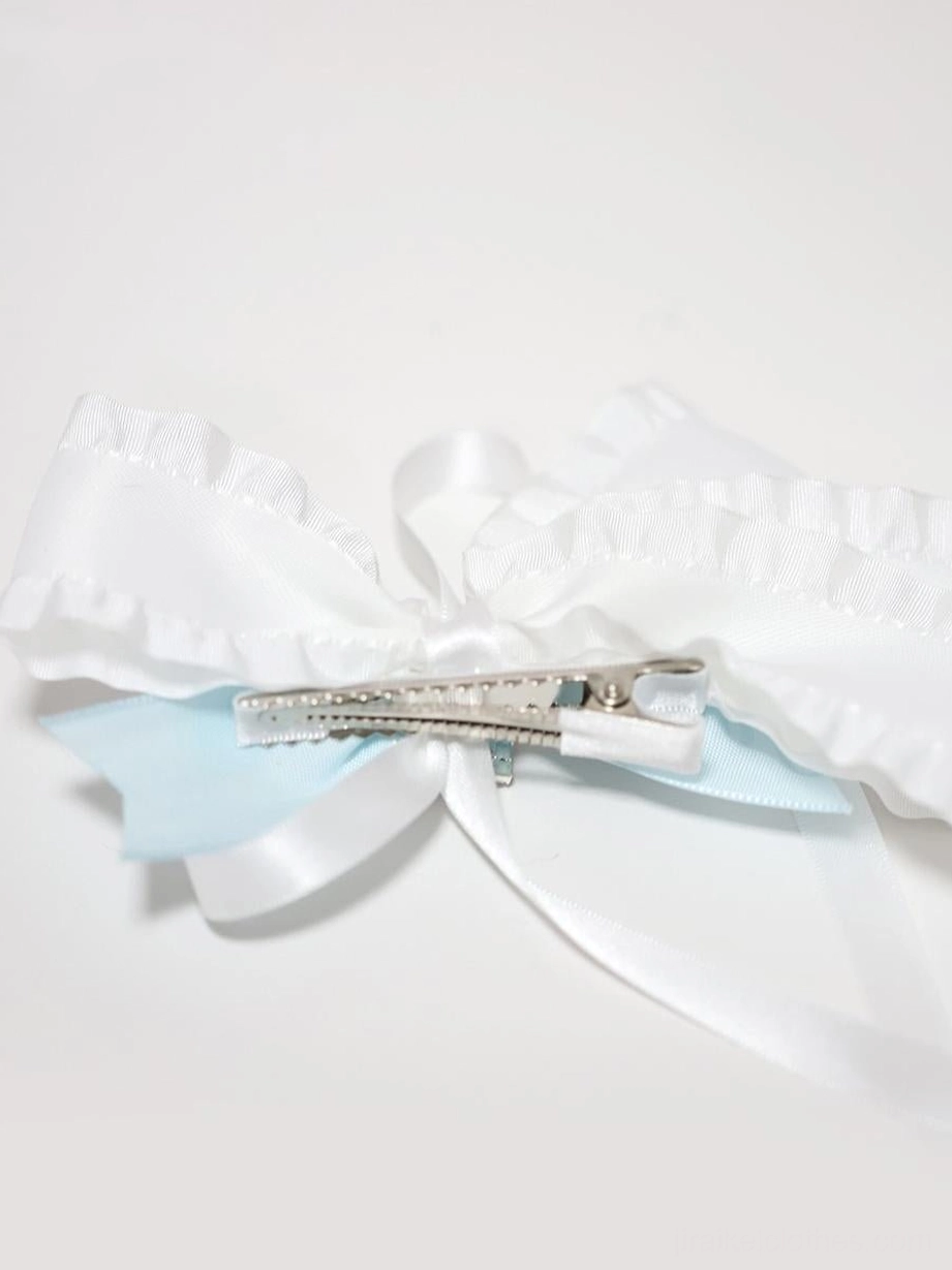 Butterfly hair clip back top-down view flat lay displaying satin ruffled bow structure and light blue ribbon accent detail