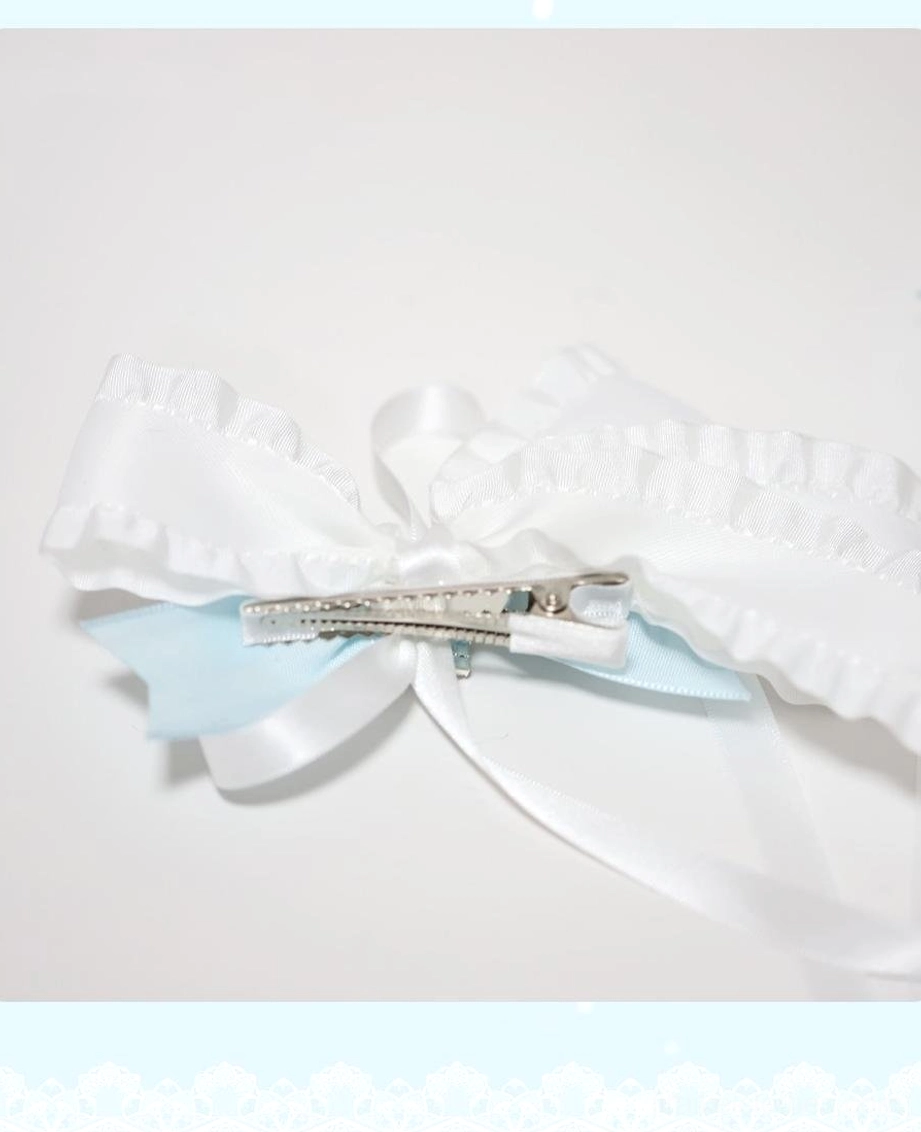 Single butterfly hair clip back side view flat lay showing ruffled white satin construction and professional alligator hair clip fastener