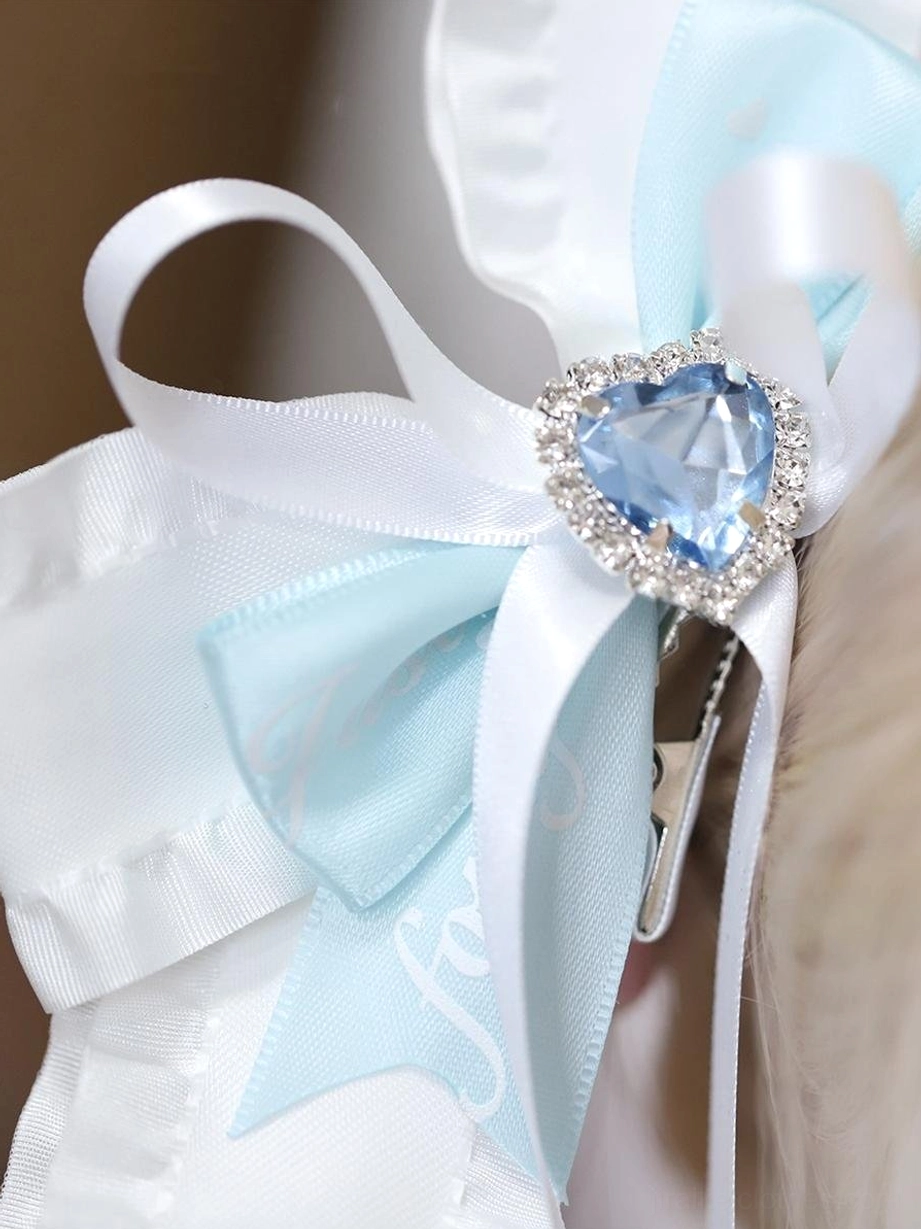Single butterfly hair clip close-up side view with heart-shaped blue gem satin ribbon and silver hair fastener detail