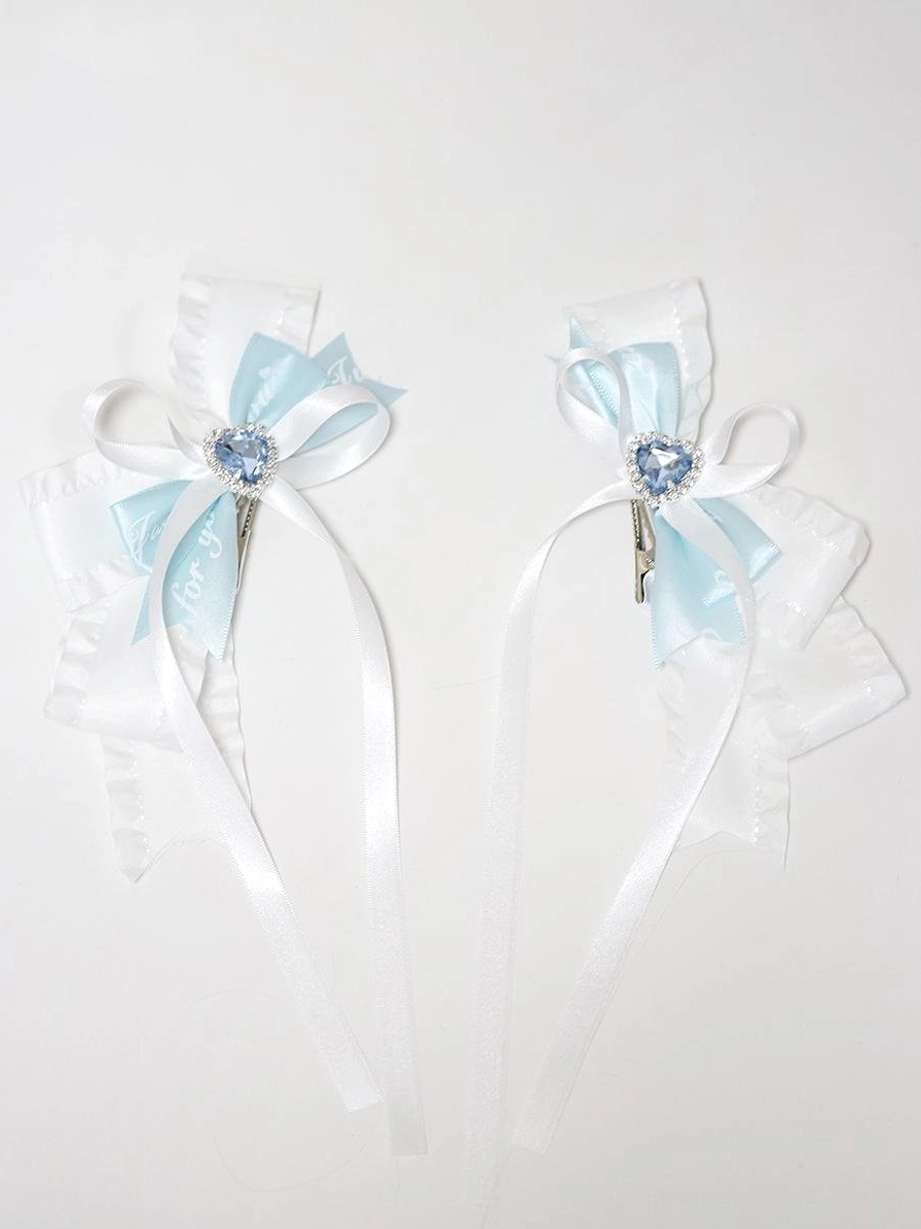 Pair of butterfly bow hair clips flat lay front view on white background showing matching bicolor white blue set with long satin ribbon tails