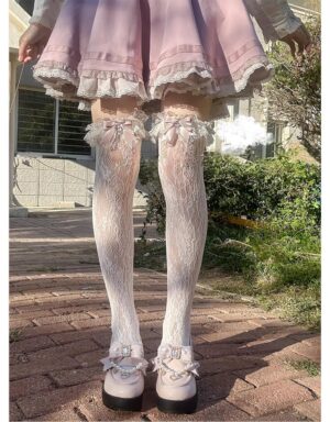 White floral jirai kei lace over-the-knee socks with ruffled rhinestone bow trim and heart charms back view modeling