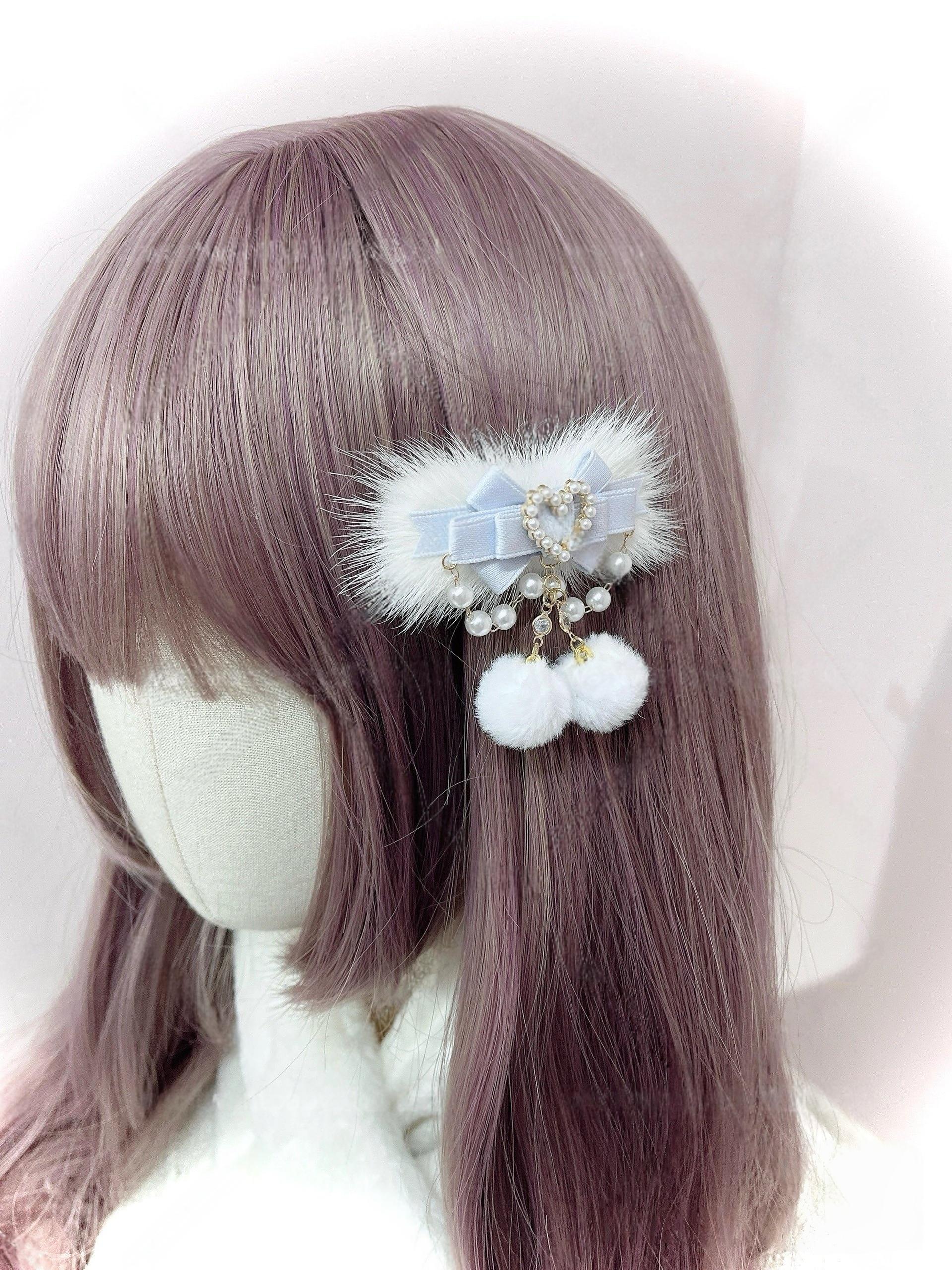 Light blue aqua satin ryousangata hair clip with pearl heart pendant and double white pom-pom drops on mannequin with straight purple bangs, jirai kei lolita accessory back view