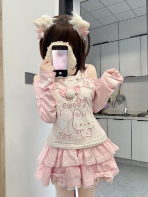 Jirai Kei cat-print off-shoulder top with white fuzzy choker and tiered multi-layer pink ruffled skirt, front full-body mirror selfie shot featuring model with cat ear hair clips and playful kawaii aesthetic styling