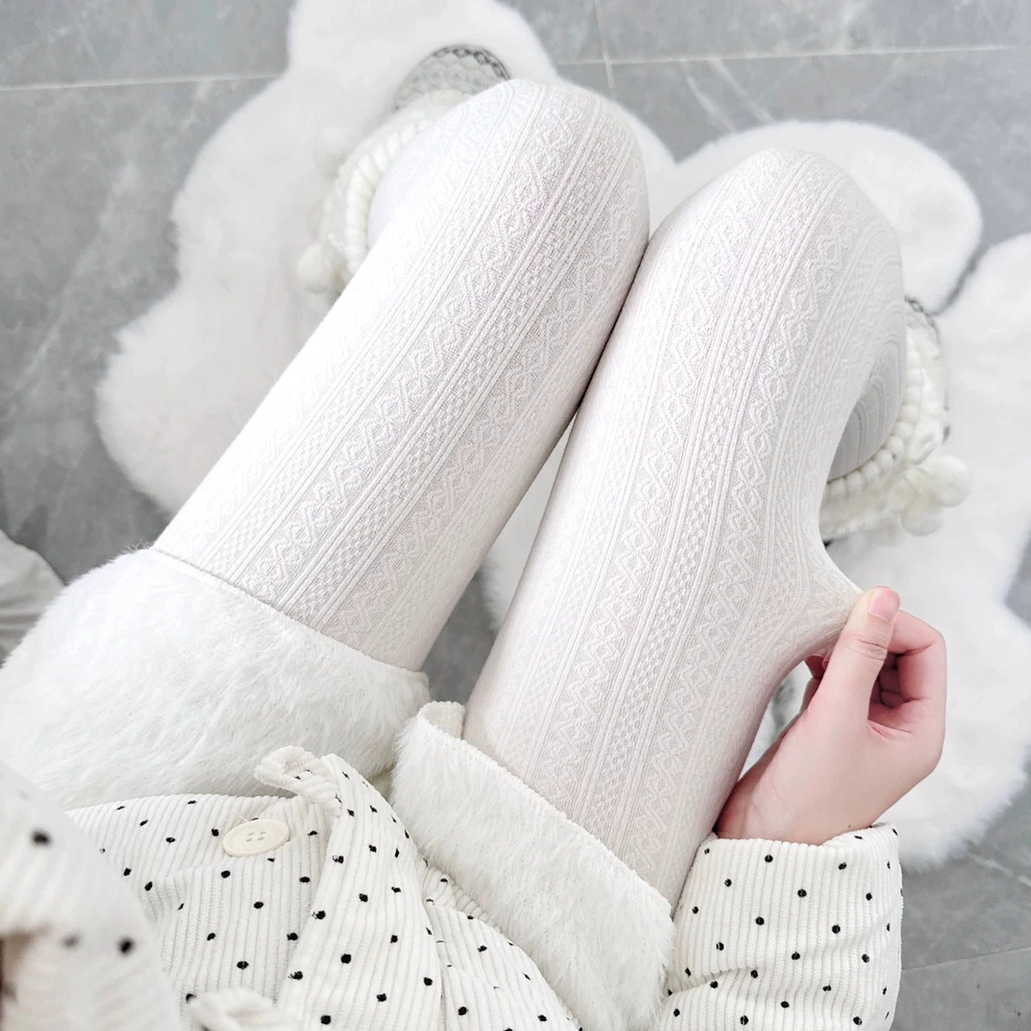 Cable knit textured footed tights in pure white displayed on legs wearing polka dot pajama set, top-down view showing twisted cable knit woven texture detail, ideal for layered Jirai Kei styling