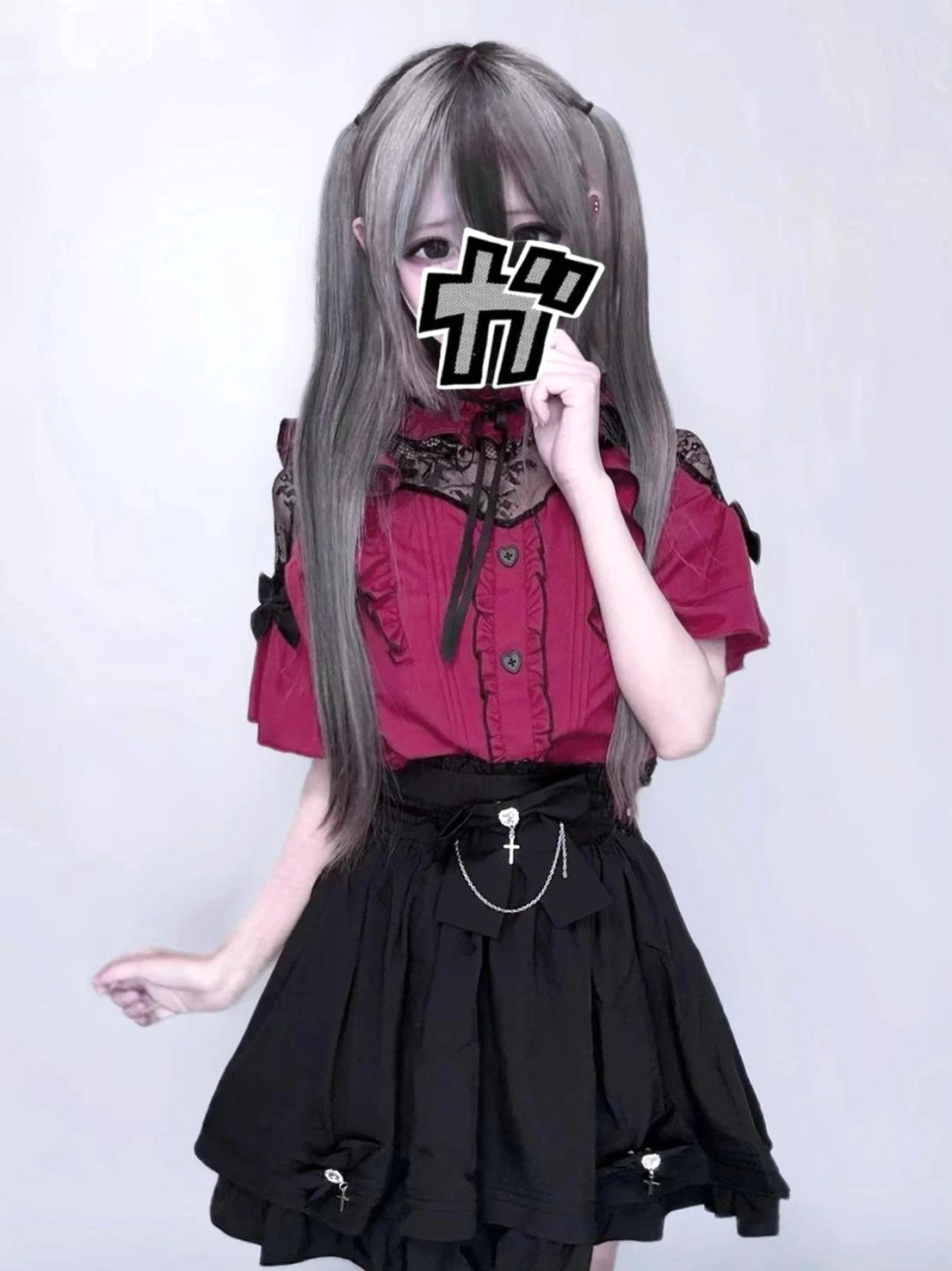 Half-body indoor portrait of casual jirai kei daily outfit featuring red lace-collar blouse, black layered high-waist skirt, cross chain waist accessory, model with grey wig