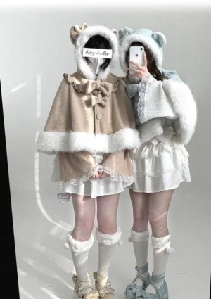 Dual model front view of cat-ear hooded cape in black-and-white and mint green colorways, featuring fluffy white trim and detachable bows in Jirai Kei aesthetic
