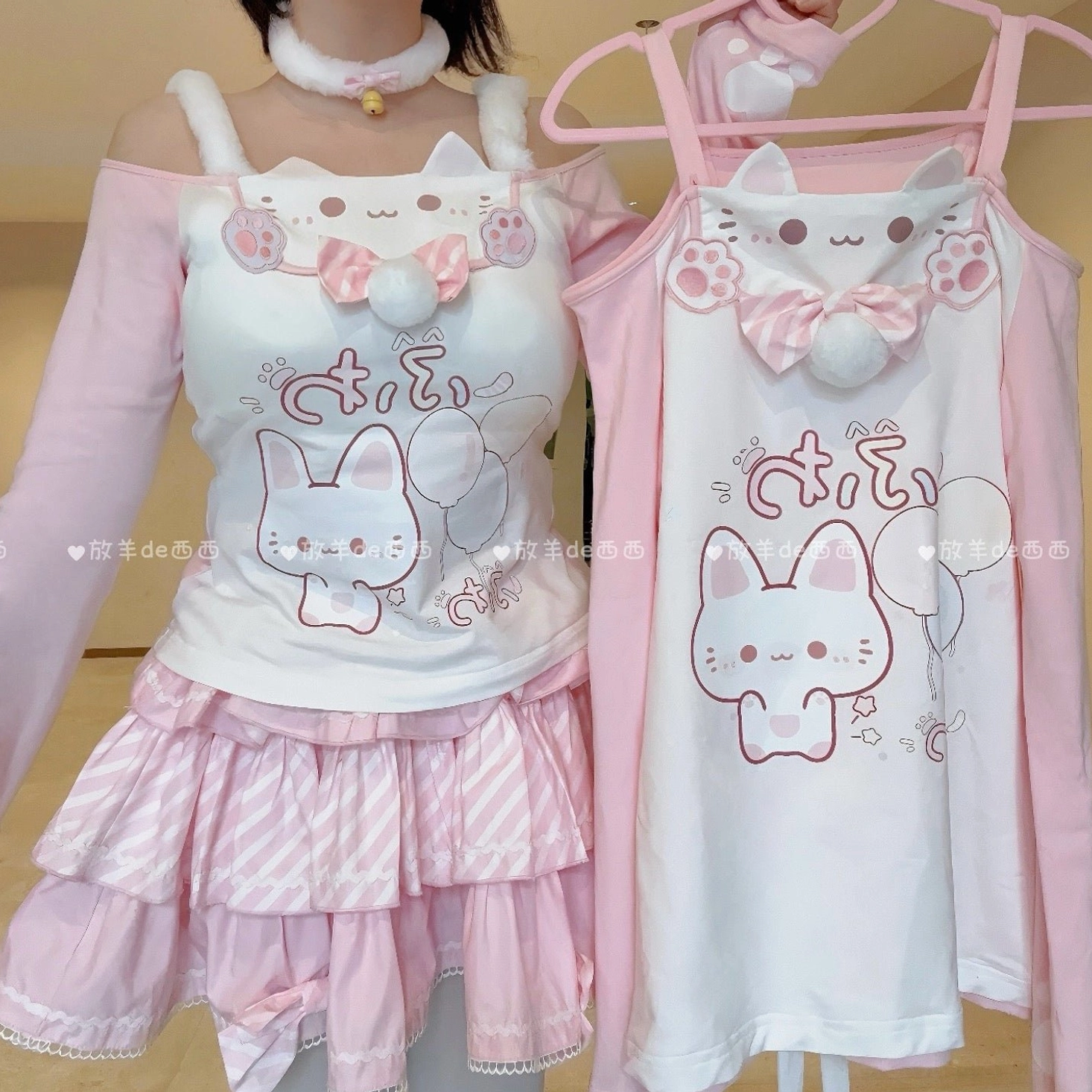 Kawaii cat-print coordinate set displayed flat on wooden surface showing off-shoulder top, tiered ruffled skirt, fuzzy choker, interchangeable shoulder straps, and pom-pom bow embellishment components