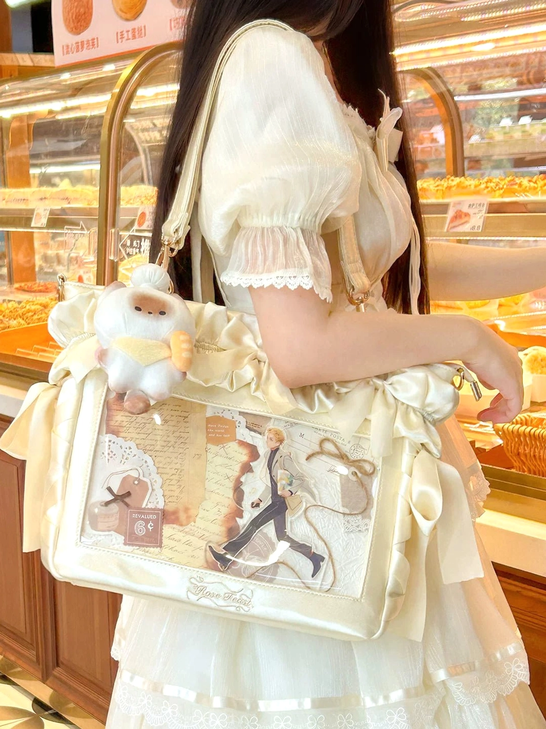 Cream white Jirai Kei laptop itabag back side view ruffled bows plush pendant clear display with comic-style character prints bakery shop setting