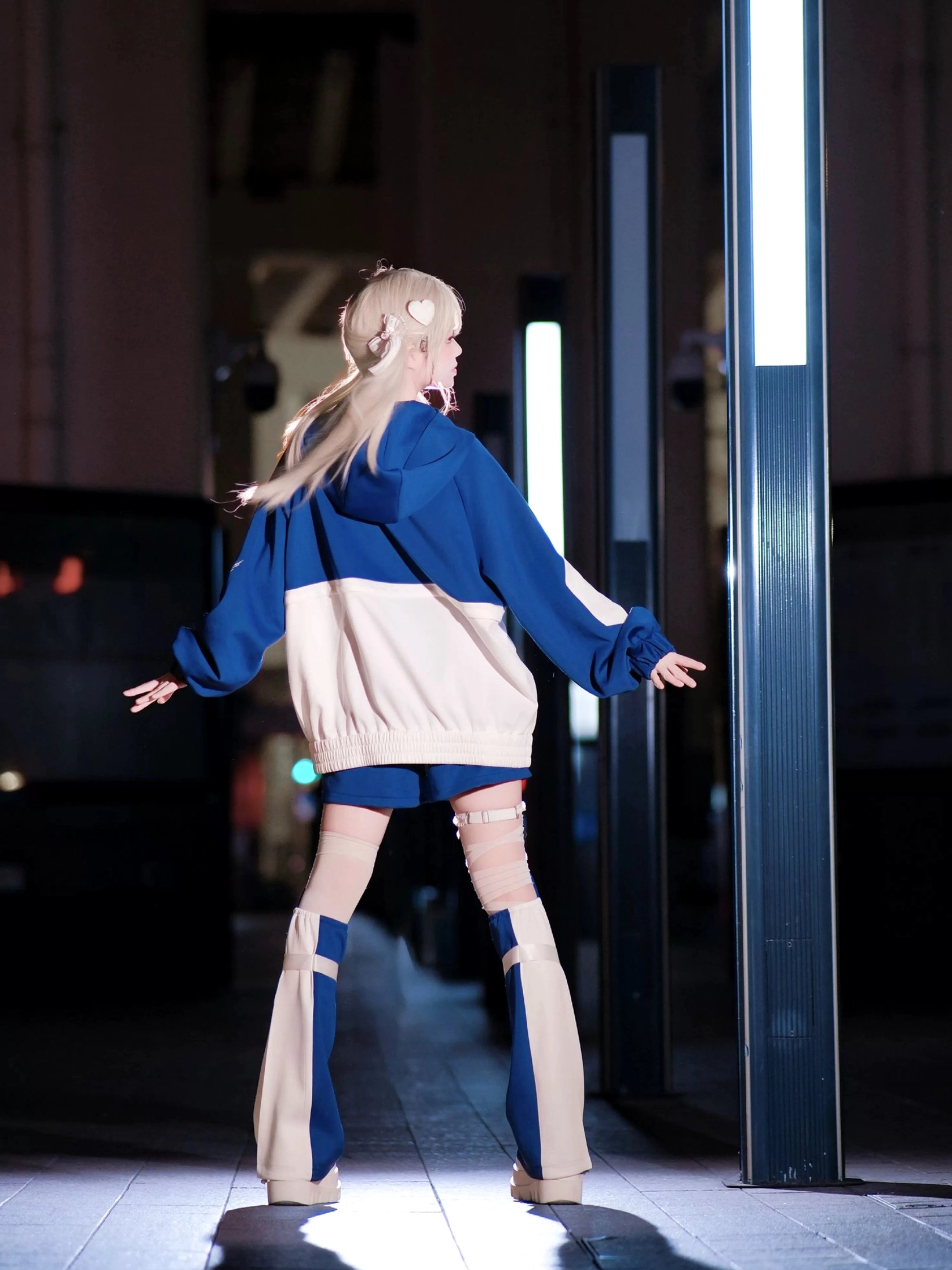 Blue white cyberpunk jirai kei outfit back view with color block jacket matching leg covers short shorts on model night street scene