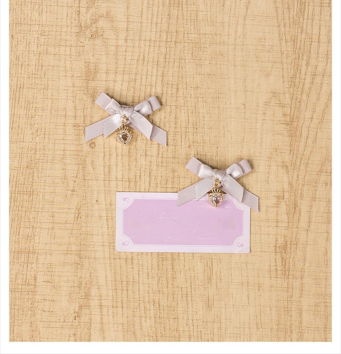Gray-pink mini bow hair clips pair showing satin bow construction with sparkling heart charm detail