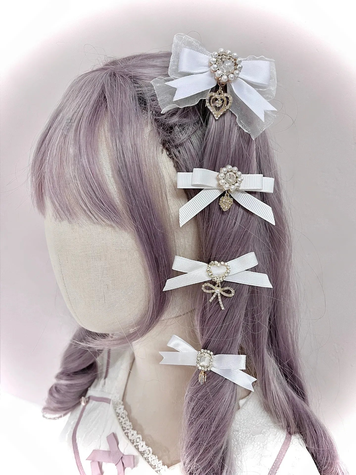 White satin bow hair clips with delicate lace trim rhinestone accents heart pendants worn on mannequin left rear angle Jirai Kei cute aesthetic