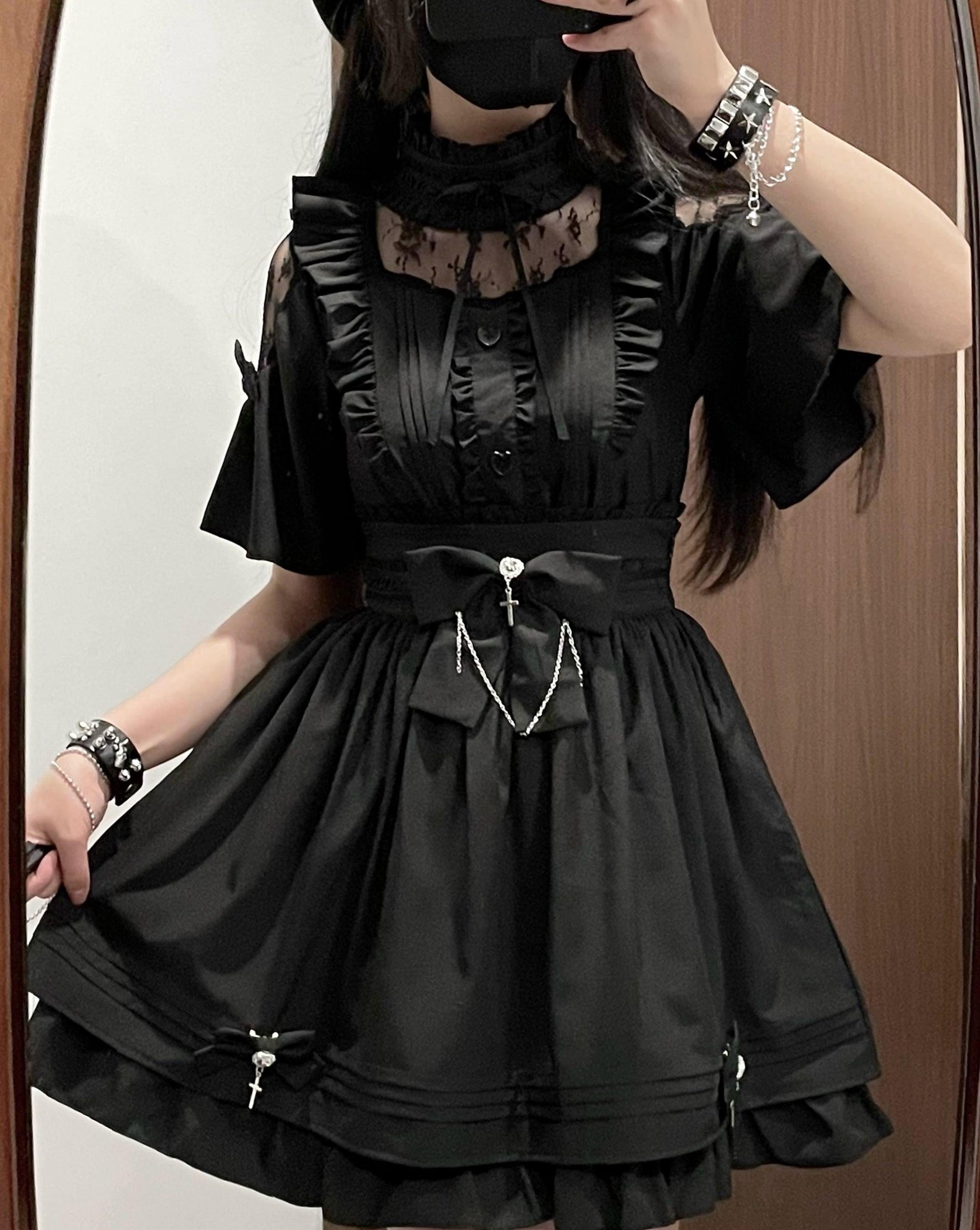 Half-body front mirror selfie of all-black jirai kei two-piece set with cold-shoulder lace neck detail, ruffled trims, detachable bow with cross chain decoration