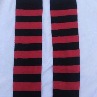 Dark blue and white striped over-the-knee socks flat lay close-up, bold contrast horizontal stripe detail, textile texture