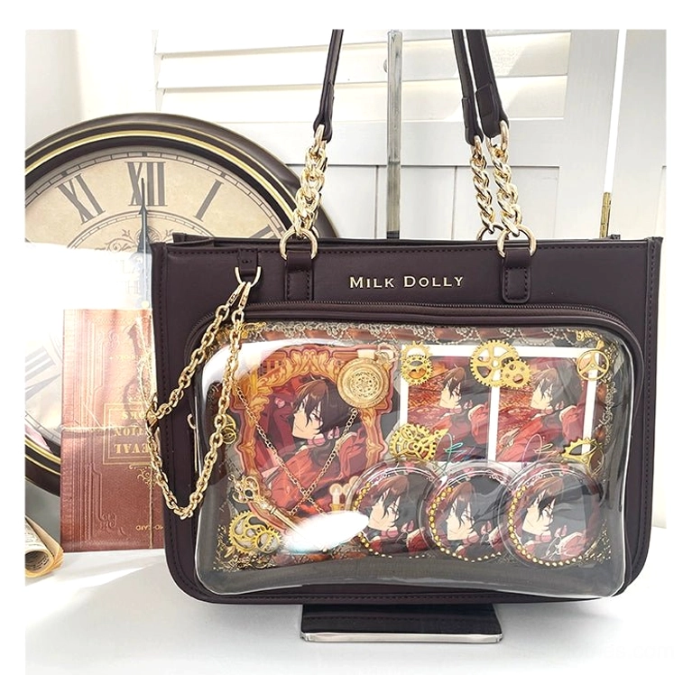 Dark brown checkered jirai kei ita bag front flat lay with anime badges and gold chain straps on vintage desktop