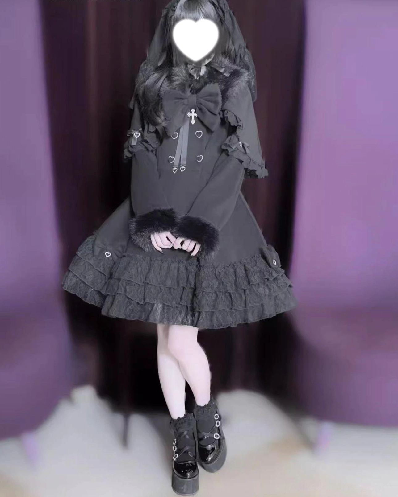 Dark gray Jirai Kei coat front view with clasped hands, lace skirt hem, fur cuffs, and cross bow decorative brooch