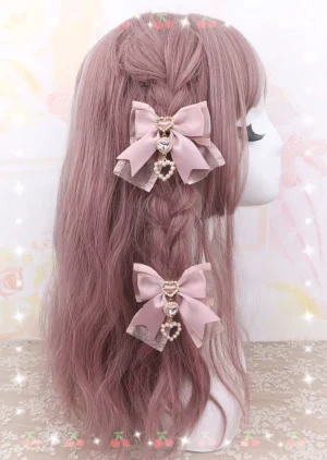 Dusty pink satin bow hair clip with heart-shaped rhinestone pendant displayed on wig mannequin - right side profile view showing detailed Jirai Kei aesthetic