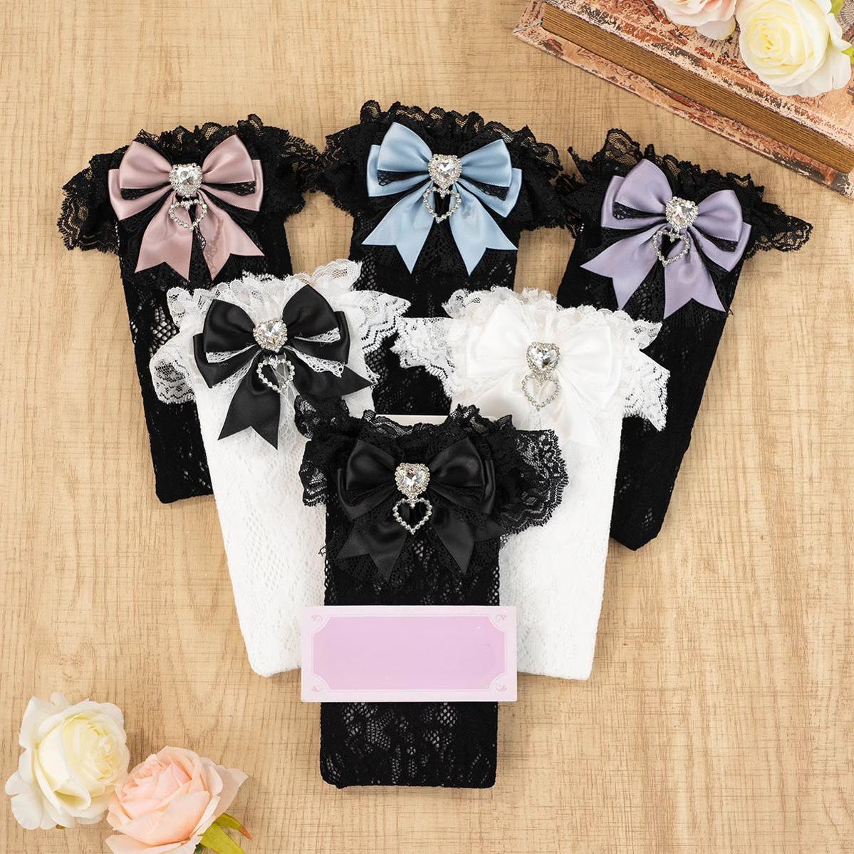 Black-purple lace knee-high Jirai Kei socks with purple bow decoration, heart rhinestone accent, ruffled lace cuff detail view