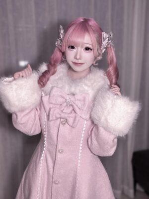 Pink Jirai Kei wool coat worn by pink-haired cosplayer model, frontal view showcasing removable faux fur collar and cuffs with bow decoration and pearl seam trim details