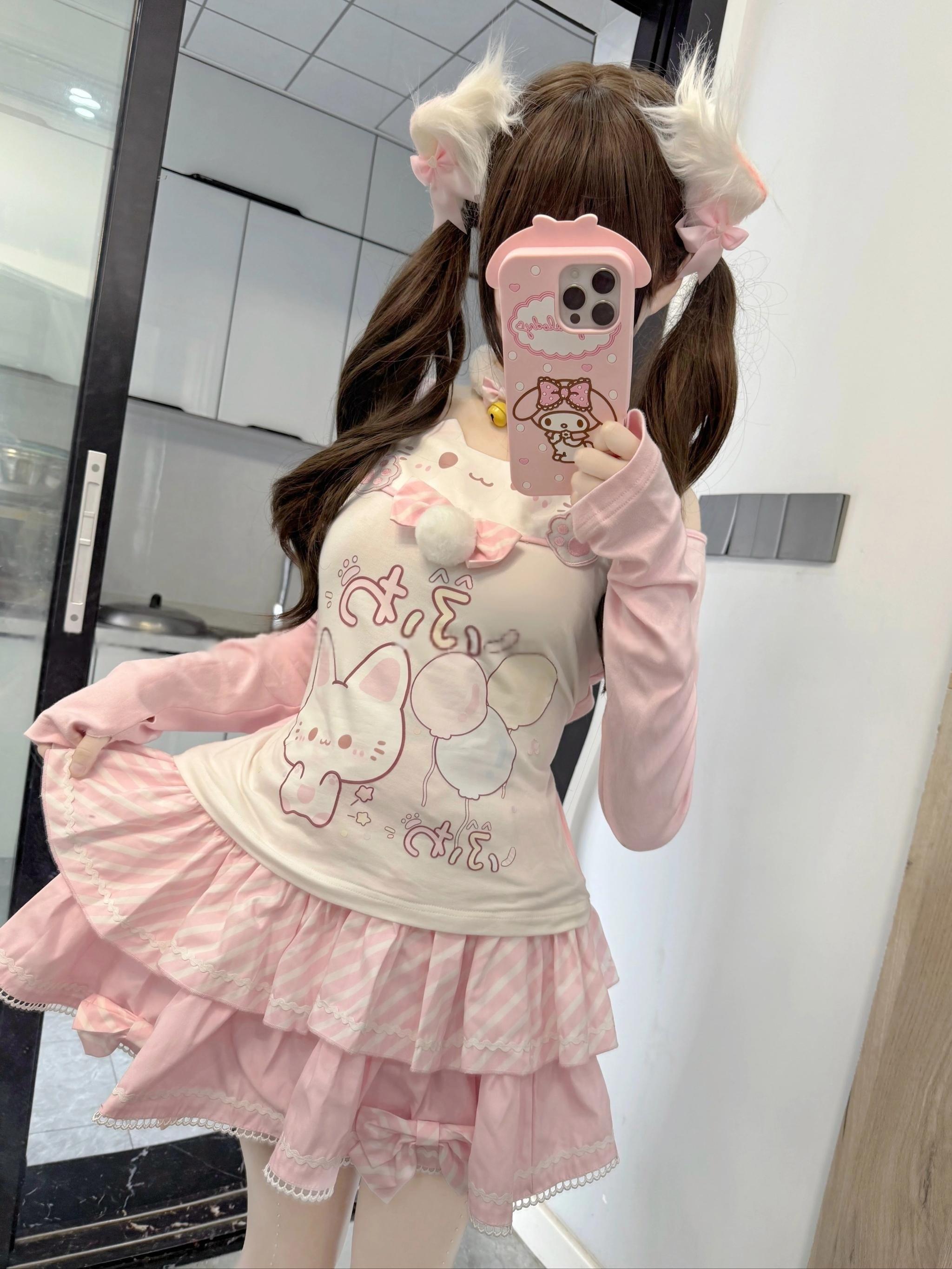 Kawaii cat-print two-piece coordinate with pom-pom bow chest decoration and layered ruffled skirt, side mirror perspective showing back silhouette and volume of tiered design with twin ponytail hairstyle
