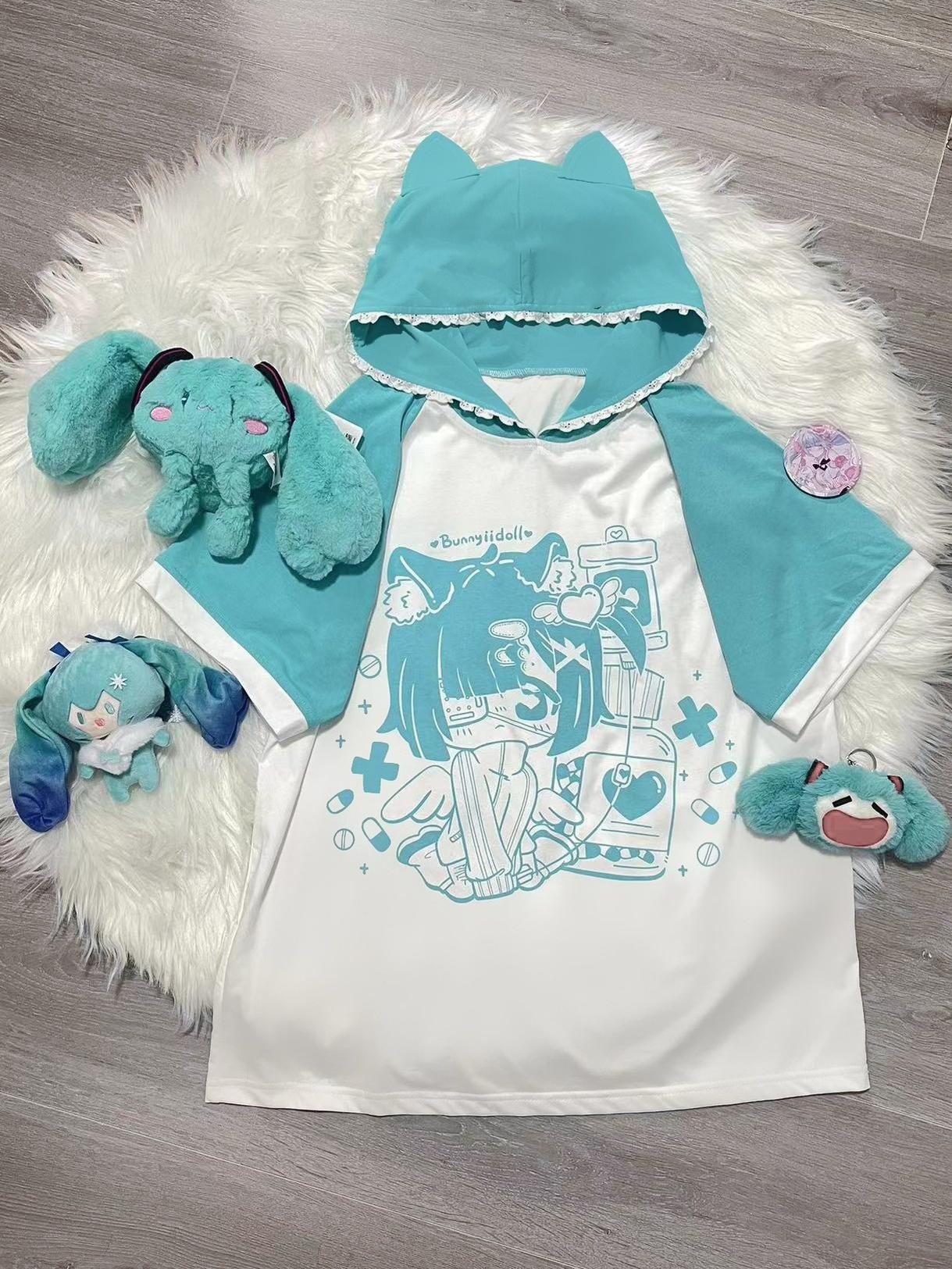 Flat lay product shot of cyan and white yami kawaii cat ear hooded anime graphic tee with lace-trimmed cat ear hood, anime girl print with symbolic imagery, plush toy accessories