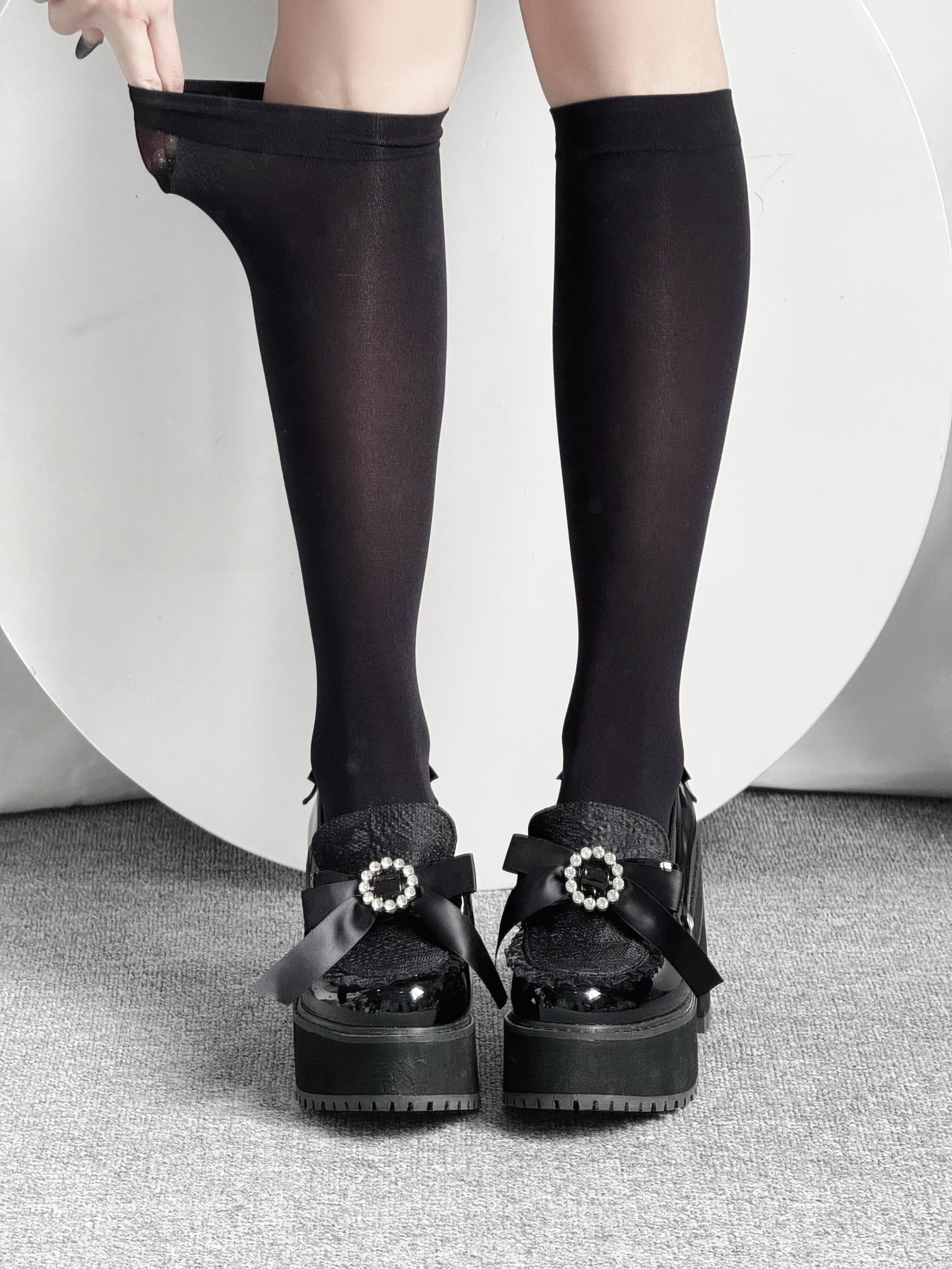 Black sheer Jirai Kei calf socks close-up front view showing elegant leg coverage with black platform bow shoes