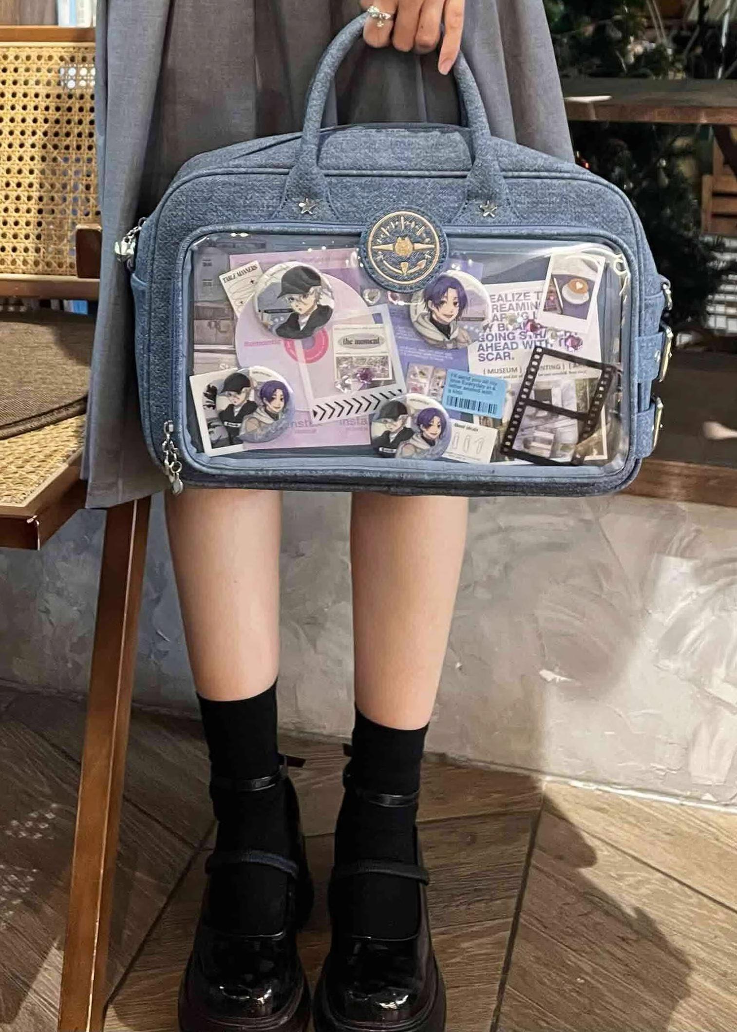 Denim blue Jirai Kei ita shoulder bag worn as top-handle style in casual indoor cafe setting, low angle lifestyle view paired with everyday outfit