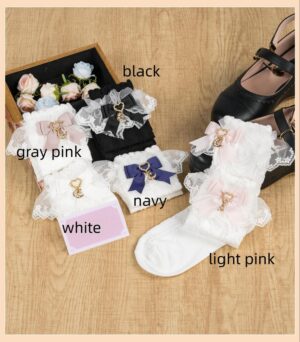 Multiple color variants of Jirai Kei style ankle socks with lace trim and moon charm bows, flat lay styling with flowers and black Lolita shoes