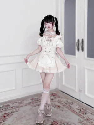 Full body front view of pink and white gingham Jirai Kei maid outfit set with ruffled detachable apron, Peter Pan collar, and heart button accents worn indoors