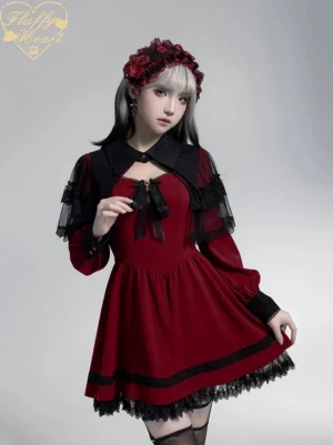 Wine red Gothic Jirai Kei dress with detachable waist cincher and lace overskirt, front three-quarter view on model with two-tone hair, showing asymmetrical lace design
