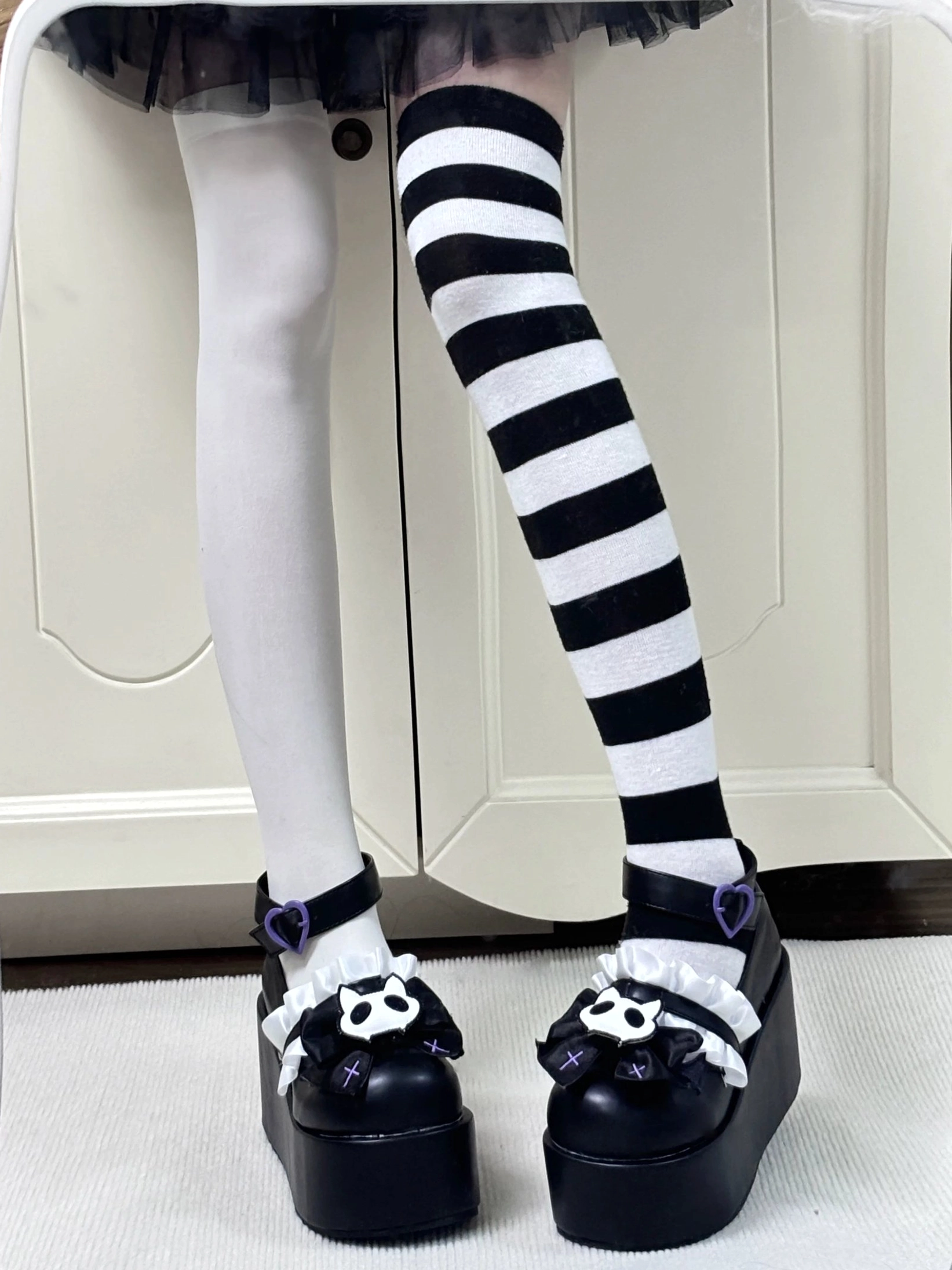 Full leg view of black gothic platform Mary Jane shoes with purple heart buckle and mismatched stockings Jirai Kei aesthetic