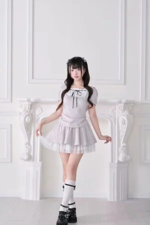 Light gray Jirai Kei lolita-inspired hoodie skirt set with white tulle hem, puff sleeves and bow neck detail, three-quarter front view