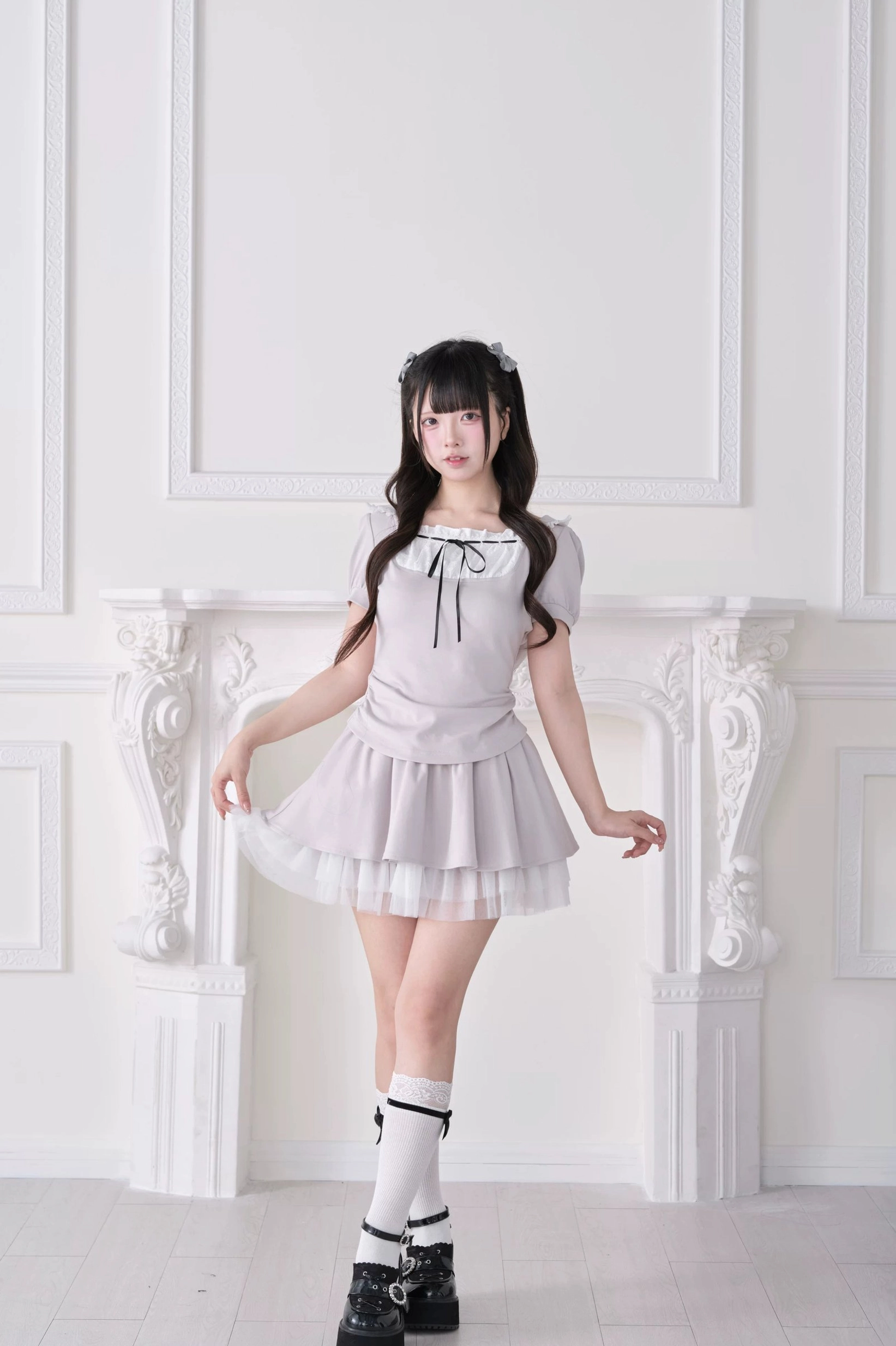 Light gray Jirai Kei lolita-inspired hoodie skirt set with white tulle hem, puff sleeves and bow neck detail, three-quarter front view