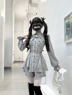 Grey striped Jirai Kei dress set with detachable bow collar and ruffled shorts, front three-quarter view on model wearing twin-tails and indoor hallway background, showcasing waist-cinching fit and bishop sleeves